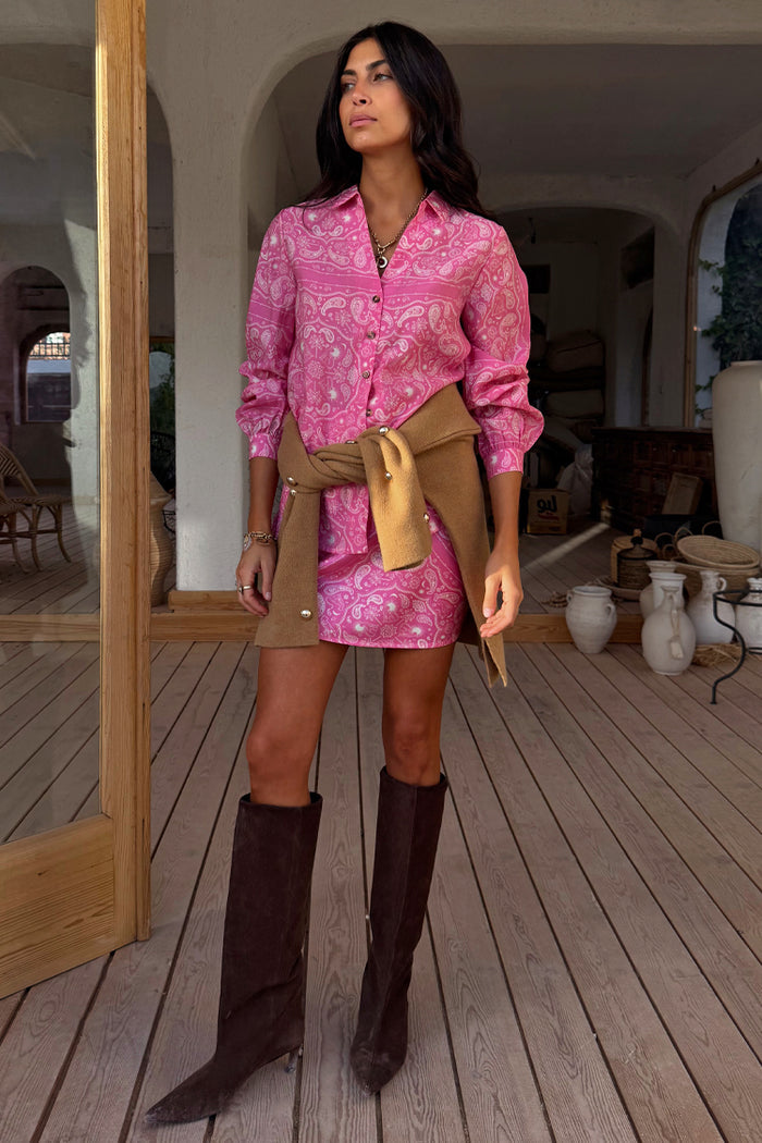 Pink Bandana Mini Dorris Skirt and matching shirt with a tan jumper tied at the waist and brown boots.
