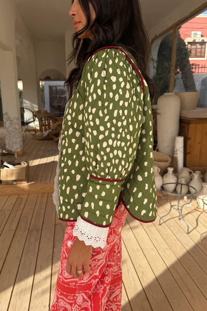 Green deer print reversible quilted jacket with burgundy trim and white lace cuff detailing.