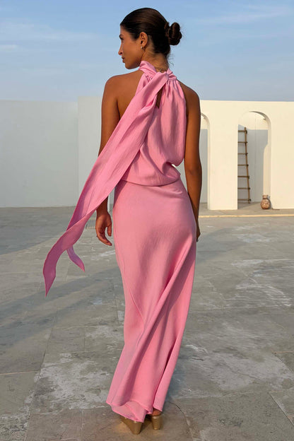 Soft pink Daphne Skirt and matching halter neck top with long ties, shown from the back in an architectural outdoor setting.