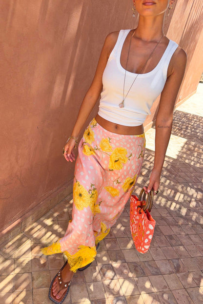 Pink Fawn Poppy Midi Maeva Skirt featuring yellow poppy motifs and a contrast lace border, styled with a white tank.