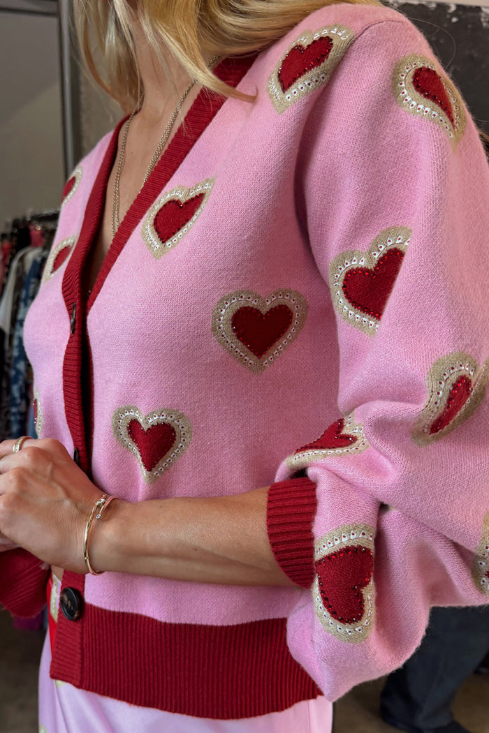 Pink Hearts Cardigan in a soft knit featuring red heart embroidery and red ribbed trims.