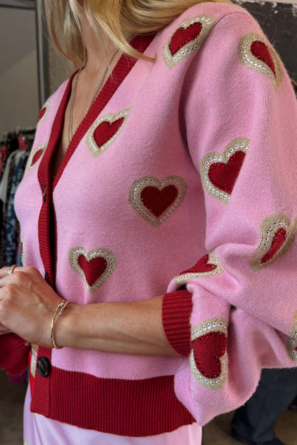 Pink Hearts Cardigan in a soft knit featuring red heart embroidery and red ribbed trims.