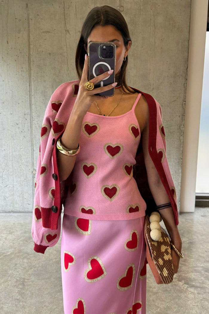 Pink Hearts Knit Tank with red heart prints, styled in a mirror selfie with a matching cardigan and skirt co-ord.
