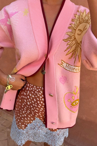 Pink Mystical Cardigan with sun and moon jacquard motifs, burgundy trims and a transeasonal soft knit finish.