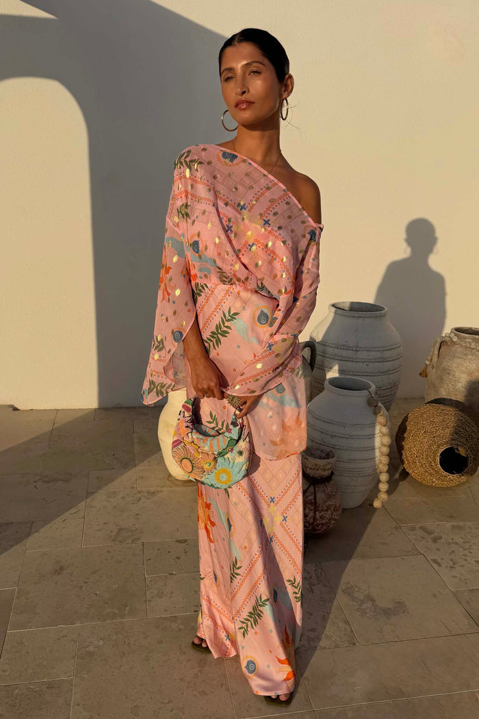 Pink Sun Anais Dress featuring iconic soleil sun motifs, gold flecks and a sheer off-shoulder draped top.