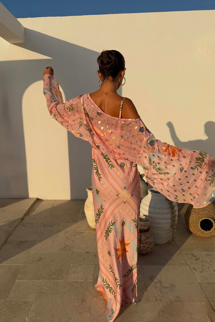 Pink Sun Anais Dress featuring a sheer off-shoulder top and gold flecks over a bias-cut skirt with soleil motifs.