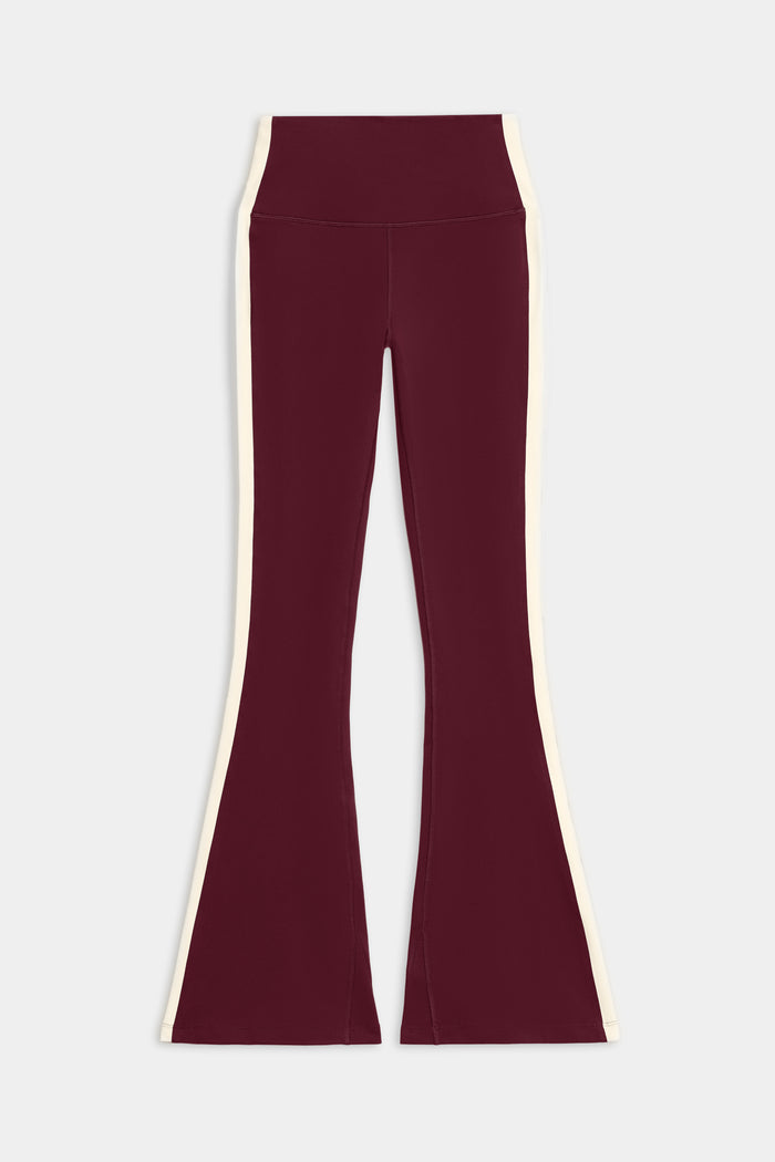 The SPLITS59 Raquel High Waist Flared Legging in Dark Cherry/Creme, made from 4-way stretch supplex, is shown laid flat on a white background.