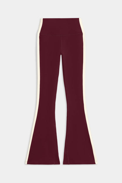 The SPLITS59 Raquel High Waist Flared Legging in Dark Cherry/Creme, made from 4-way stretch supplex, is shown laid flat on a white background.