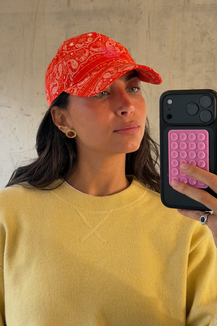 Red Bandana Cap featuring a pink embroidered NFD logo, styled with a yellow ribbed sweater on a model.