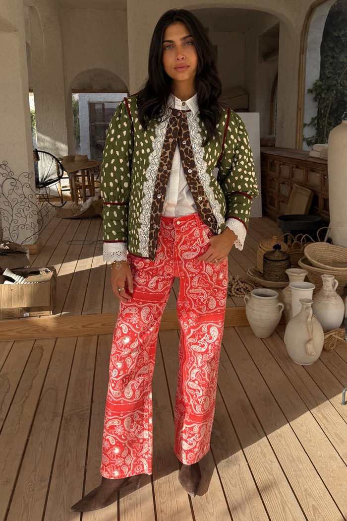 Red Bandana Jeans in a straight leg fit with a white bandana print, styled with a quilted jacket in an airy room.