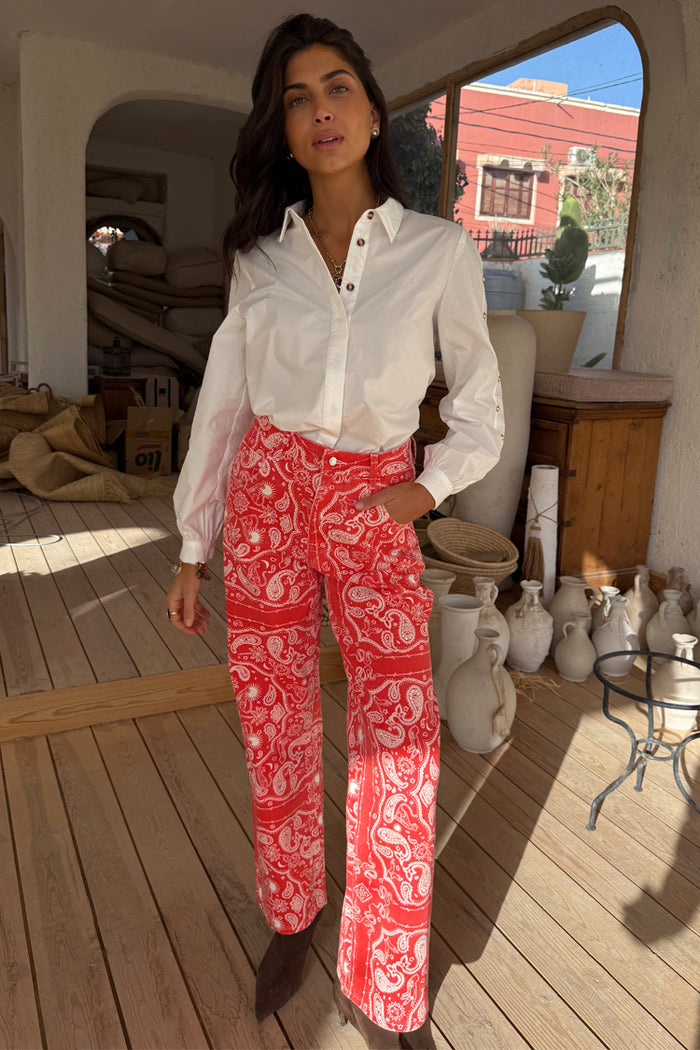 Red Bandana Jeans with a bold paisley print and straight-leg silhouette, styled with a white button-down shirt.