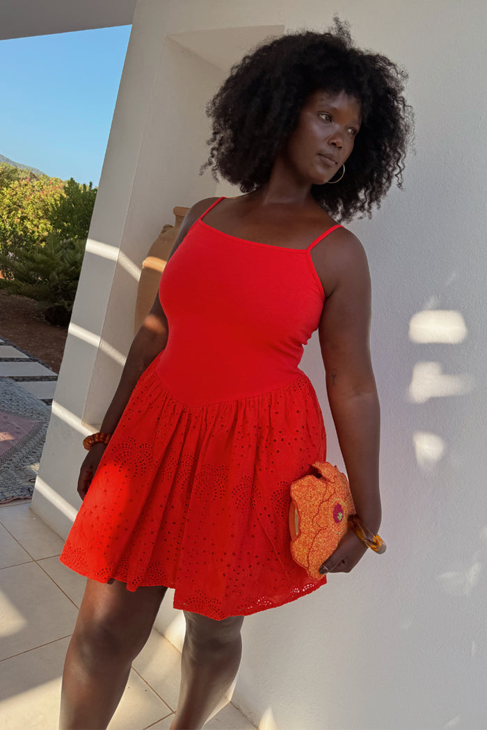 Red Broderie Mini Lola Dress in cotton with palm patterns, styled for vacation and inclusive fashion.