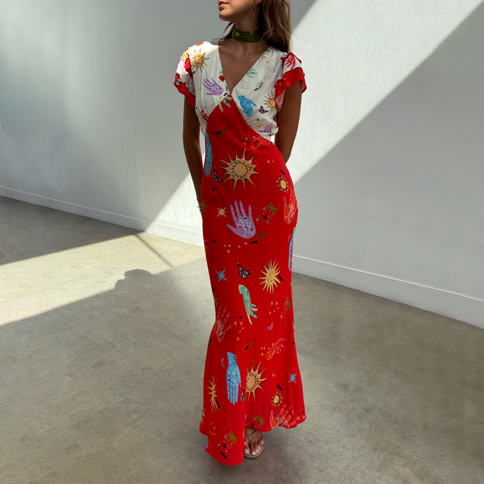 Red Celestial Midi Dress featuring a V-neckline and colourful sun and hand motifs on a cream and red viscose base.