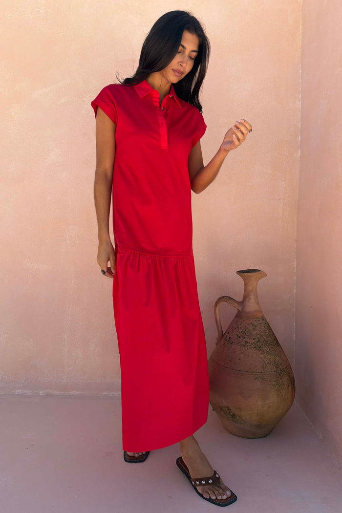 Red Darcy midi dress in bright cotton featuring a dropped waist and collared neckline, styled beside a clay vase.