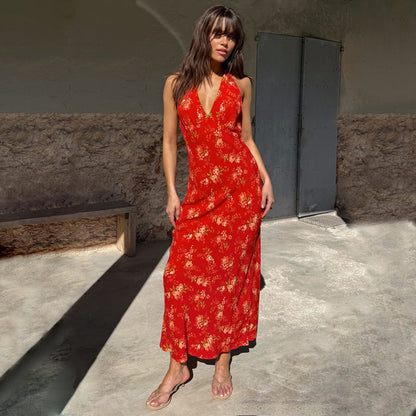 Red Floral Halter Dress with a vintage pink and green floral print, green neckline trim and bow detail, worn outdoors.