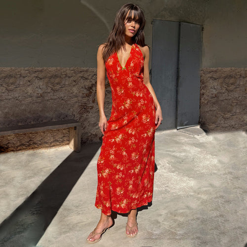 Red Floral Halter Dress with a vintage pink and green floral print, green neckline trim and bow detail, worn outdoors.