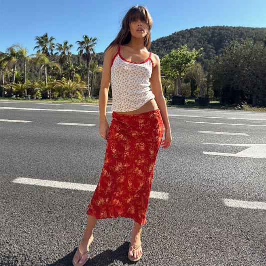 Red floral midi skirt in viscose, styled with a floral pointelle lace vest on an outdoor sunny road.