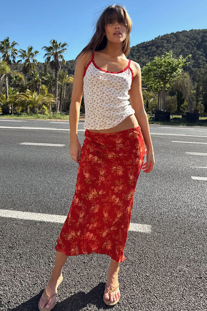 Red Floral Midi Skirt and white pointelle vest with red lace trim, styled for a summer vacation look outdoors.