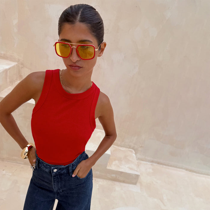 Red ribbed tank top wardrobe staple styled with dark jeans and yellow sunglasses for dopamine dressing.
