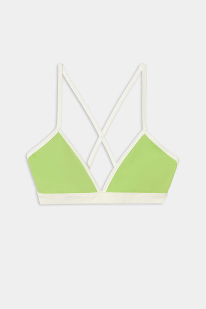 The SPLITS59 Sage Rigor Bra in Limeade/White features a light green design with white trim, thin crisscross back straps, and is crafted from a soft nylon-spandex blend. It is showcased on a plain white background.