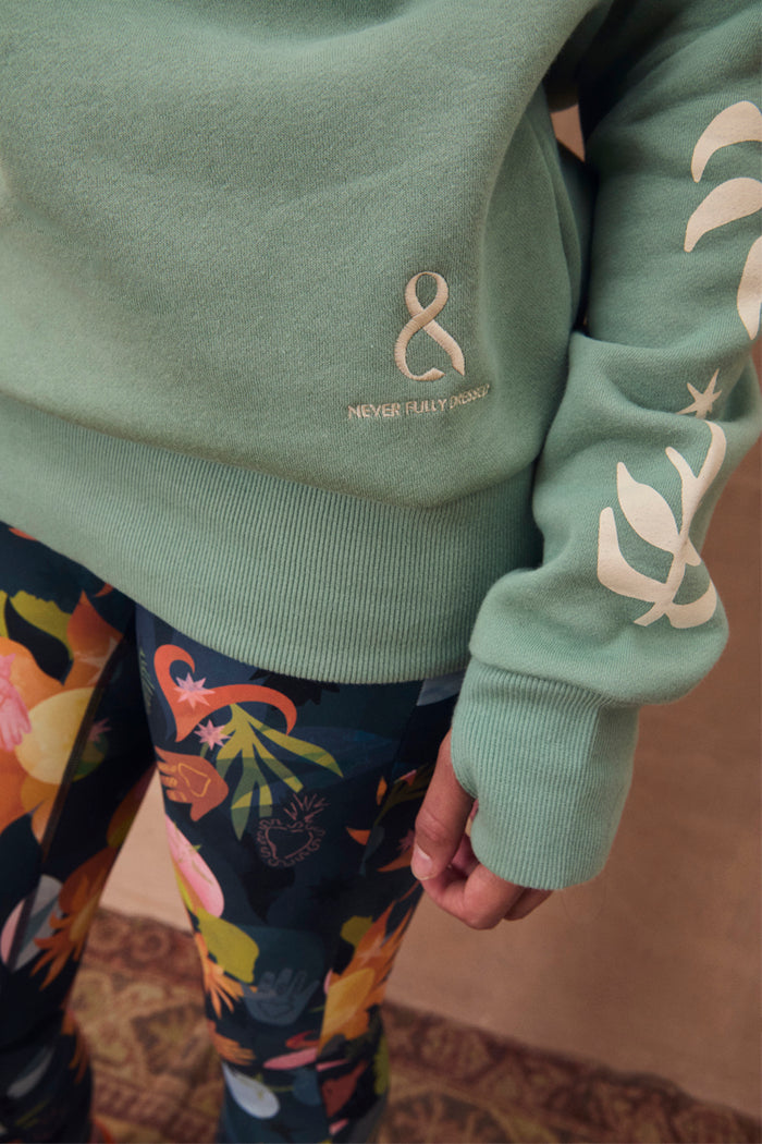 Sage Sundazed Accessible Sweatshirt with cream palm print, embroidered logo, and thumb hole detail.