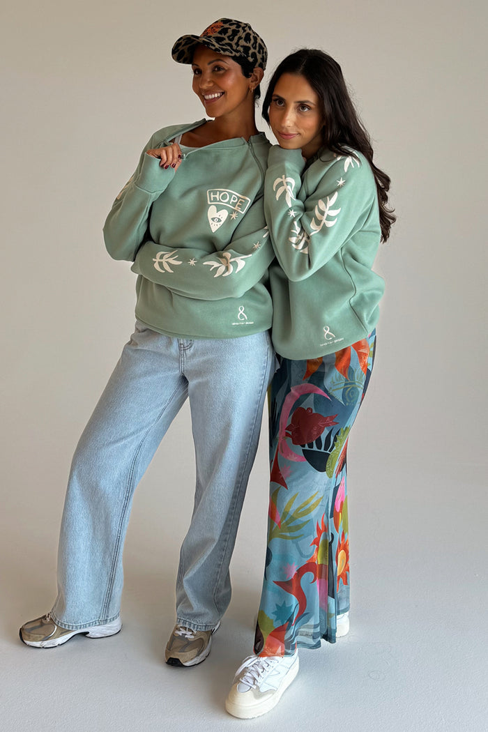 Sage Sundazed Accessible Sweatshirt with cream palm prints, HOPE graphic and concealed zips, worn by two models.