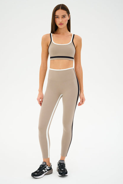 Dressed for gym workouts, the person is wearing a SPLITS59 Sam High Waist Rigor 7/8 set in Latte/Black and black sneakers.