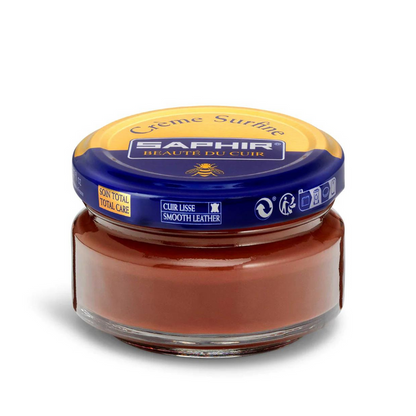 A jar of Saphir Creme Surfine shoe polish with a label on the lid.