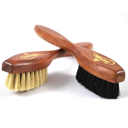 A long-handled spatula-shaped shoe polish applicator brush with black & neutral bristles and a wooden handle.