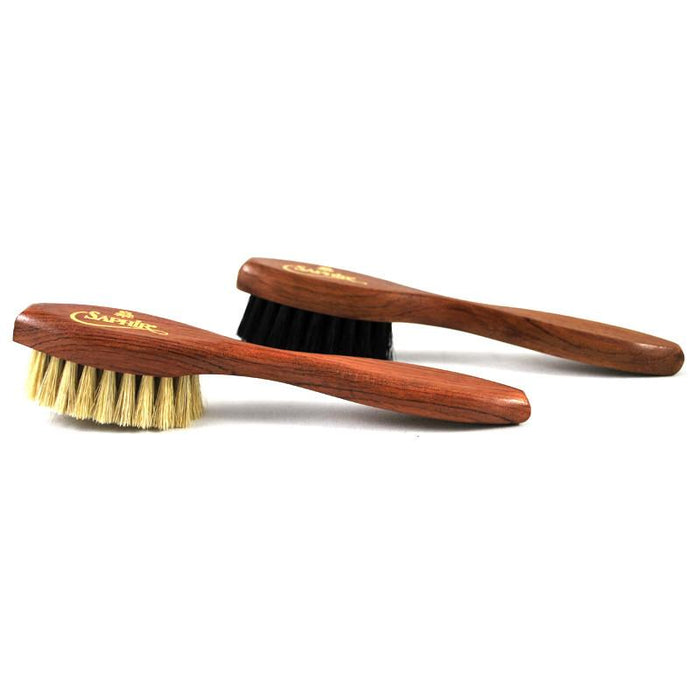 A long-handled spatula-shaped shoe polish applicator brush with black & neutral bristles and a wooden handle.