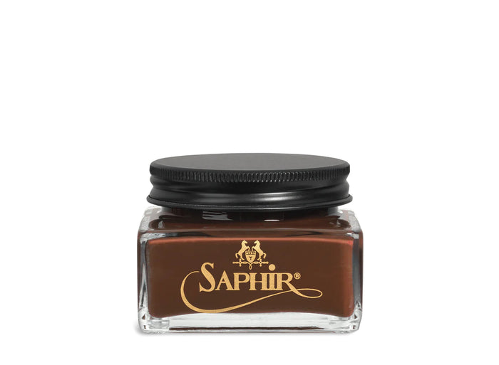 A glass jar with a black lid labeled 'SAPHIR' containing cream shoe polish.