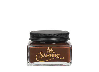 A glass jar with a black lid labeled 'SAPHIR' containing cream shoe polish.
