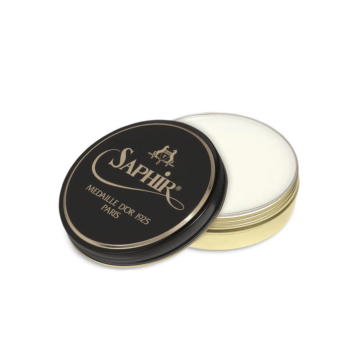 A round tin of Saphir Medaille D'Or Dubbin Grease with the lid off, showing the white dubbin inside. The tin has a black label with gold text and the Saphir logo.