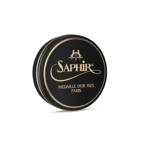 A round tin container of Saphir Medaille D'Or shoe wax polish with a black lid and label featuring gold text and accents.