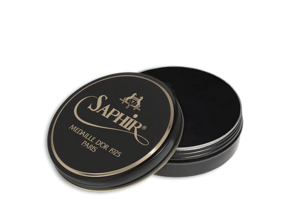 A round tin container of Saphir Medaille D'Or shoe wax polish with black lid and gold lettering.