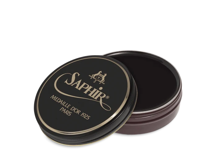 A round tin container of Saphir Medaille D'Or shoe wax polish with black lid and gold lettering.