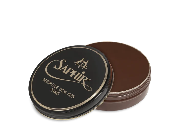 A round tin container of Saphir Medaille D'Or shoe wax polish with black lid and gold lettering.