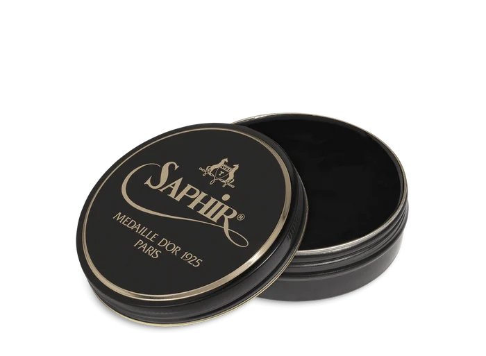 A round tin container of Saphir Medaille D'Or shoe wax polish with black lid and gold lettering.