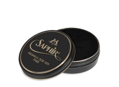A round tin container of Saphir Medaille D'Or shoe wax polish with black lid and gold lettering.