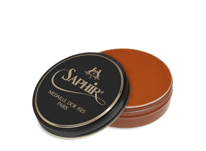 A round tin container of Saphir Medaille D'Or shoe wax polish with black lid and gold lettering.