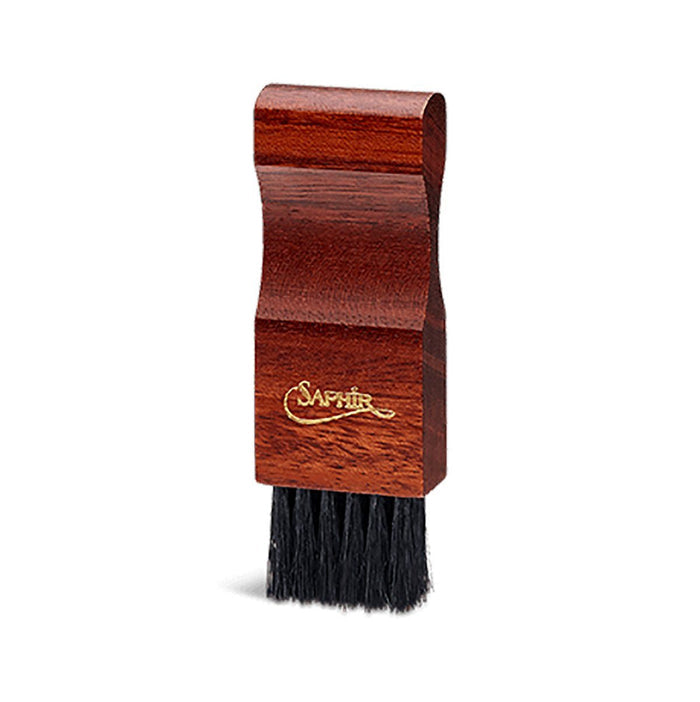 A crepe suede brush with a beige bristle head and a brown exotic wood handle.