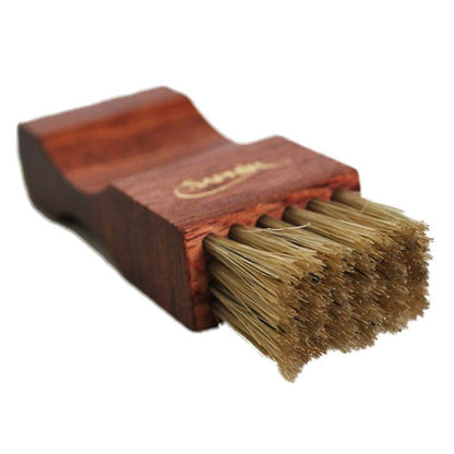 A crepe suede brush with a beige bristle head and a brown exotic wood handle.