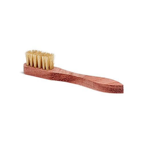 A small shoe polish applicator brush with a wooden handle and natural white boar bristles.