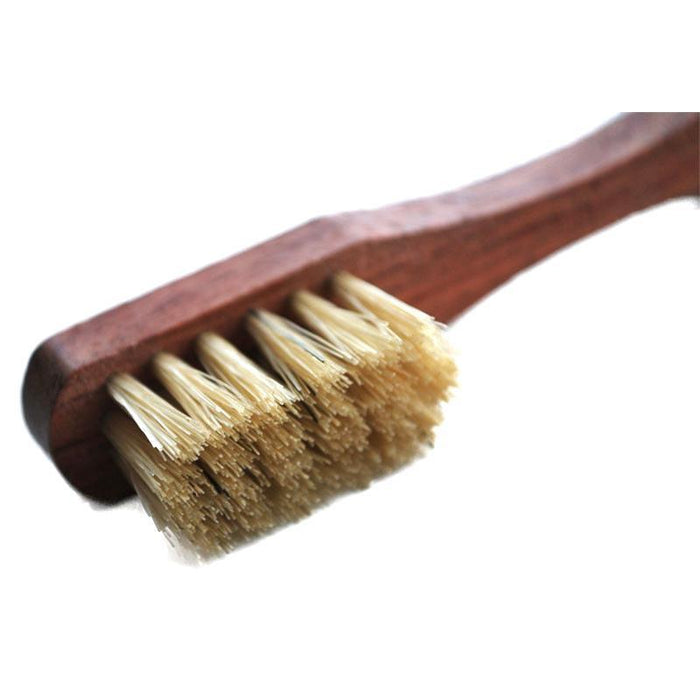 A small shoe polish applicator brush with a wooden handle and natural white boar bristles.