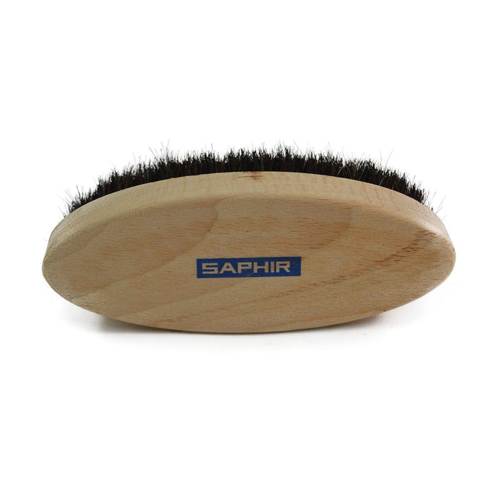 An oval shoe shine brush with horsehair bristles, with natural black bristles, wooden handle, on a white background.