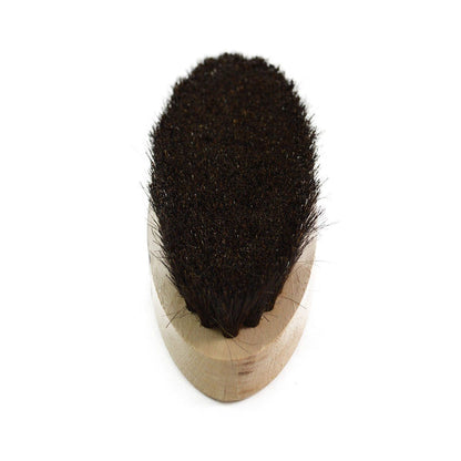 An oval shoe shine brush with horsehair bristles, with natural black bristles, wooden handle, on a white background.
