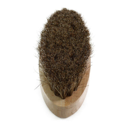 An oval shoe shine brush with horsehair bristles, with natural brown bristles, wooden handle, on a white background.