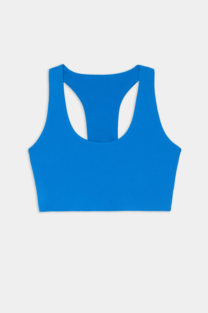 The SPLITS59 Sara Airweight Bra in Classic Blue, featuring a sleeveless racerback design ideal for hot yoga or Pilates, is displayed flat on a white background.
