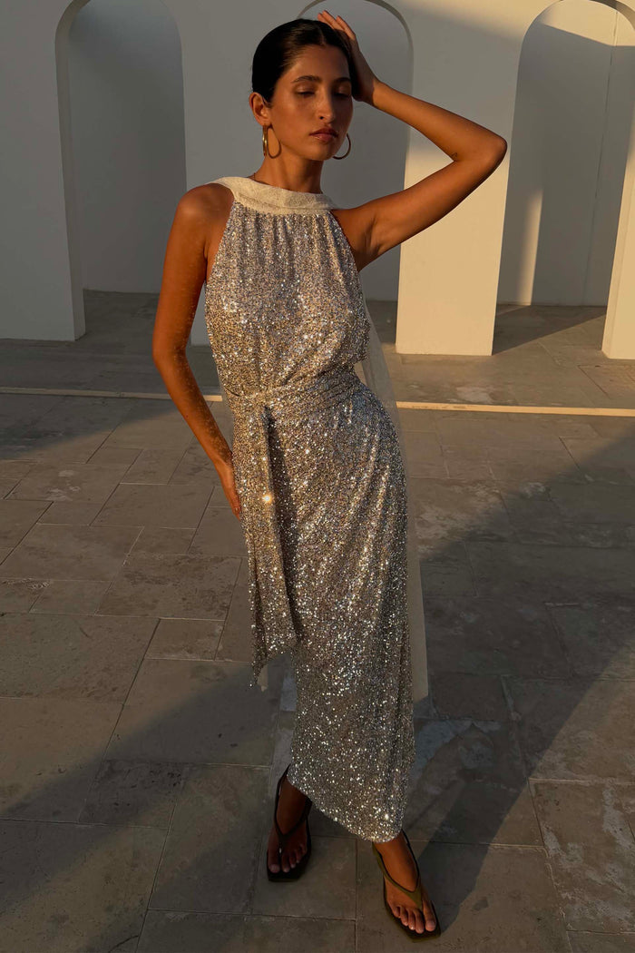 Silver Sequin Maxi Wrap Jaspre Skirt styled as a multi-wear halter dress in a sunlit architectural setting.
