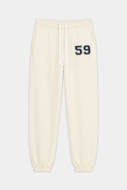 The Serena French Terry Oversized Sweatpant by SPLITS59 in Creme/59 is crafted from soft 100% cotton, featuring an elastic waistband, drawstring, cuffed ankles, and a black and white “59” detail on the left thigh.